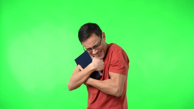 Male bookworm in glasses hugging favorite book