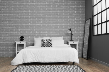 Interior of stylish bedroom with nightstand, mirror and soft rug