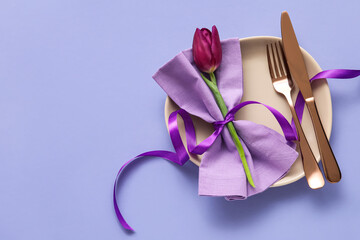 Elegant table setting and flower on purple background