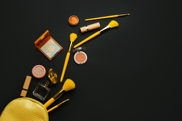 Composition with makeup brushes and cosmetic products on dark background