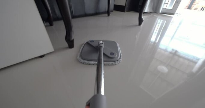 POV home floor cleaning with a mop. Woman cleaning floor with mop in home
