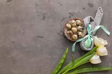 Bowl with Easter eggs and tulip flowers on grey grunge background