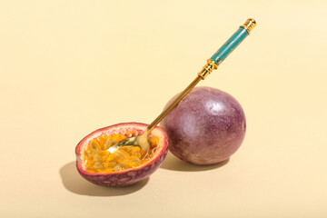 Spoon with delicious passion fruits on yellow background