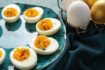 Plate and holder with eggs on green background, closeup. Easter celebration