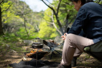 キャンプで焚火をする男性