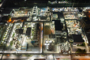 Aerial view of petrochemical oil refinery and sea in industrial engineering concept in Bangna district at night, Bangkok City, Thailand. Oil and gas tanks pipelines in industry