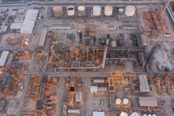 Aerial view of petrochemical oil refinery and sea in industrial engineering concept in Bangna district at night, Bangkok City, Thailand. Oil and gas tanks pipelines in industry