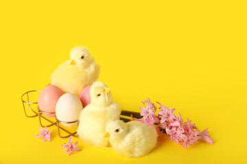 Cute chickens, spring flowers and Easter eggs on yellow background