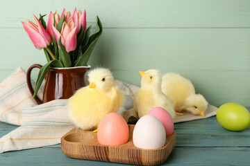 Cute chickens, tulips and Easter eggs on table