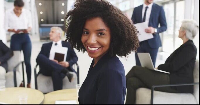 Shes everywhere where success is in the making. 4k video footage of a young businesswoman smiling in an office with her colleagues in the background.