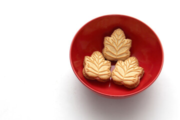 Delicious cookies filled with vanilla cream made with honey or maple syrup from Canadian trees, the traditional sweet of Canada in a red bowl of heart shape

