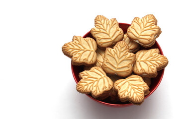 Delicious cookies filled with vanilla cream made with honey or maple syrup from Canadian trees, the traditional sweet of Canada in a red bowl of heart shape
