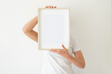 A wooden frame with empty space in women's hands
