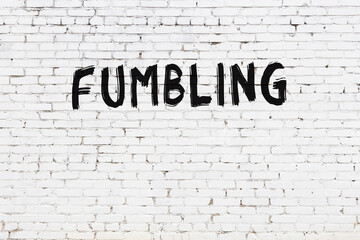 Inscription fumbling painted on white brick wall