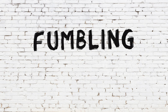Inscription fumbling painted on white brick wall