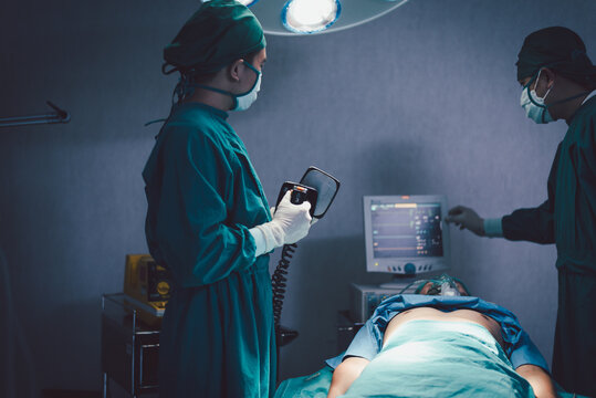 Medical urgency doctor using defibrillator during surgical operation a patient in hospital operating room