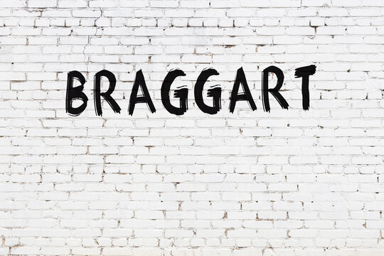 White wall with black paint inscription braggart on it