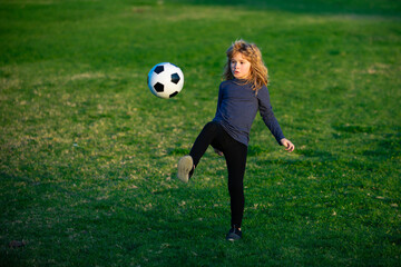 Young soccer player in sportswear with soccer ball. Cheerful little boy enjoy soccer, football...