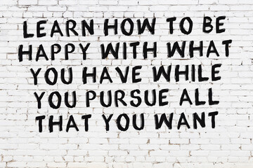 Painted black mindful inscription on white brick wall background