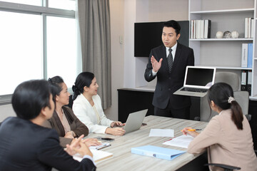 Collaborative process of professional businesspeople going over on new project together, using computer presentation and brainstorming ideas, coworker and working together at office meeting concept