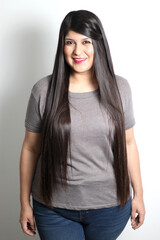 Obraz premium Overweight Latin young adult woman shows how silky and shiny her black hair is, very long, straight, very happy and proud of the beautiful hair with a beautiful haircut 