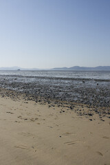 It is a beach with tidal flats.