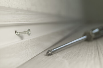 Installation of plastic skirting board in the room. Screwing to the wall of the baseboard. Repair...