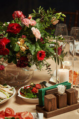 festive dinner on the table a burning candle in a candlestick and floral decor on the table