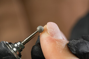 Hardware professional manicure, cleaning the skin around the nail with a cutter. Close up female...