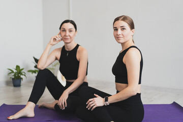 Fototapeta na wymiar Young women sit on yoga mats to start practicing meditation and yoga