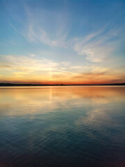 Fototapeta premium Sunset on a pond with blue sky, red clouds and water with reflection. Russia.