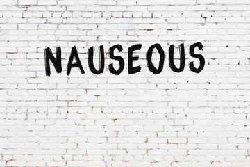 Inscription nauseous painted on white brick wall