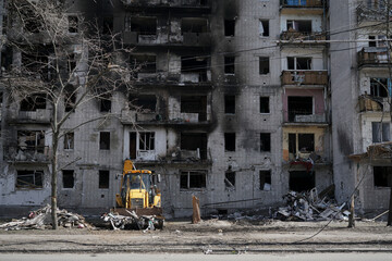 The technique clears and cleans the ruins of the house after the explosion of the projectile. Destroyed residential building without windows