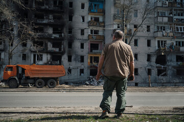 A man stands near a destroyed house that was hit by a shell from military operations in Ukraine