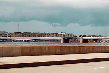 Bridge over the river on a summer day. Clouds over the city.