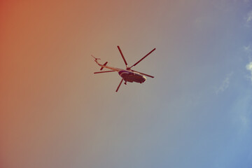 The helicopter is flying in the sky .