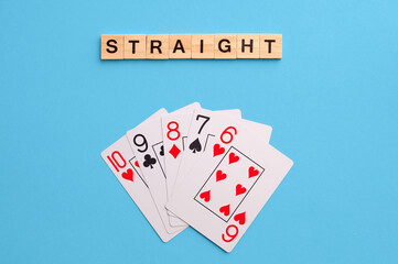Straight combination. Poker Playing Cards on blue background with wooden blocks. Flatlay, copy space, concept
