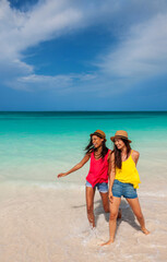 Friends wearing Panama hats standing in tropical ocean