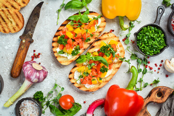 Vegan Sandwich with sweet peppers, cheese, vegetables and basil. Bruschetta. Top view. On a stone background.