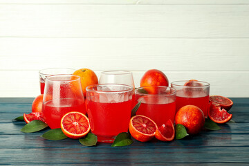 Concept of fresh drink with red orange juice on wooden table