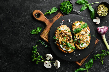 Vegan Sandwich with mushrooms, cheese and basil. Bruschetta. Top view. On a stone background.