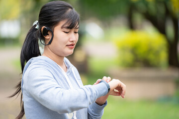 Attractive woman wearing wireless earphone before outdoor workout.Healthy lifestyle concept.