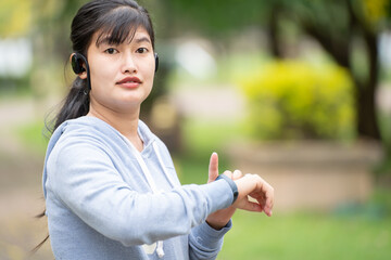 Attractive woman wearing wireless earphone before outdoor workout.Healthy lifestyle concept.