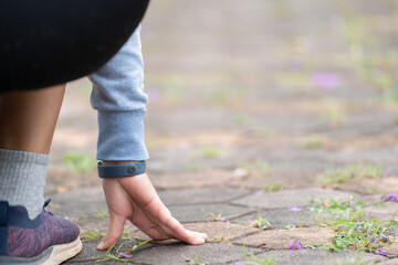 A girl in sportswear prepares to run on nature after taking a low start.The woman starts running.Girl starting running on the road to the nature background on morning