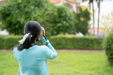 Woman is a professional photographer with  camera, outdoor and sunlight, Portrait, copy space.Beautiful woman taking picture outdoors