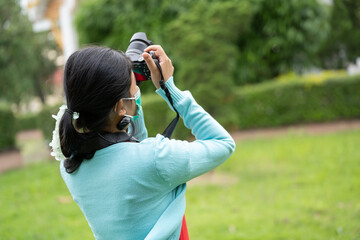 Woman is a professional photographer with  camera, outdoor and sunlight, Portrait, copy space.Beautiful woman taking picture outdoors