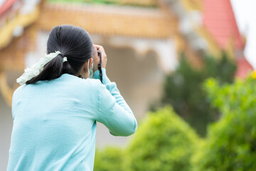 Woman is a professional photographer with  camera, outdoor and sunlight, Portrait, copy space.Beautiful woman taking picture outdoors