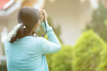 Woman is a professional photographer with  camera, outdoor and sunlight, Portrait, copy space.Beautiful woman taking picture outdoors