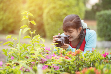 Woman is a professional photographer with  camera, outdoor and sunlight, Portrait, copy space.Beautiful woman taking picture outdoors