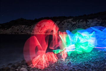 Luces movidas por una mujer en una de las playas de Jávea de noche